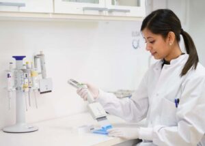 A photo of an Alphalyse employee filling an ELISA plate with sample material.